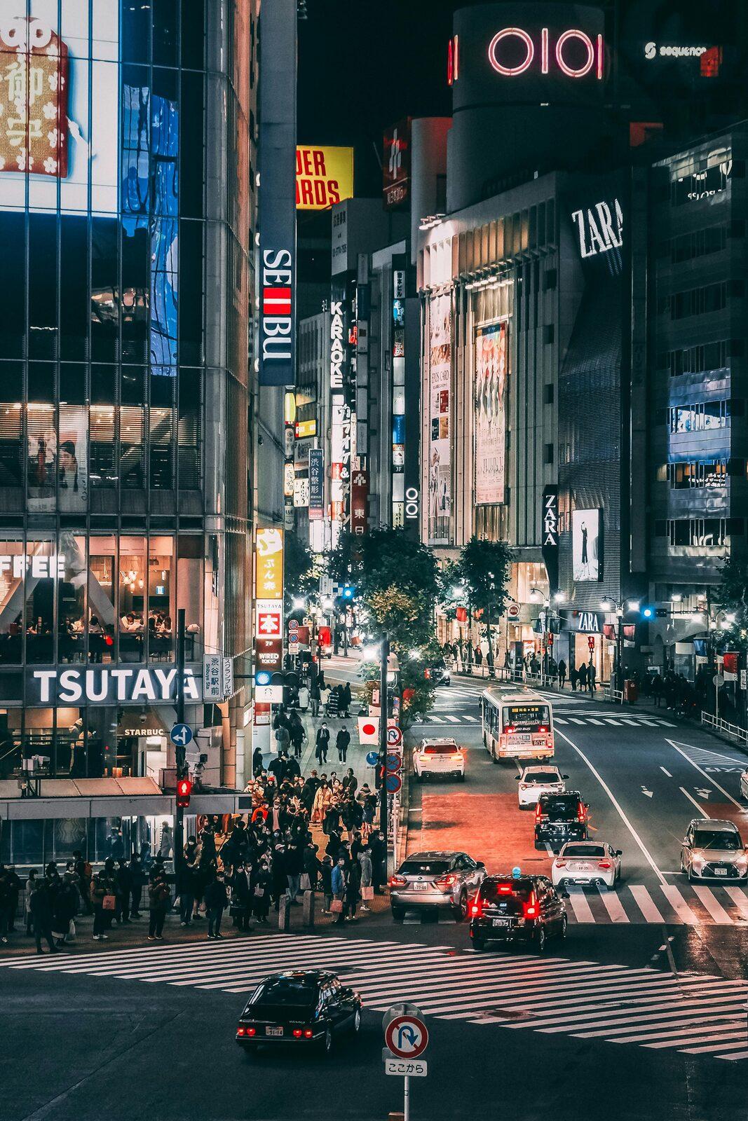 A busy shopping street in Tokyo at night