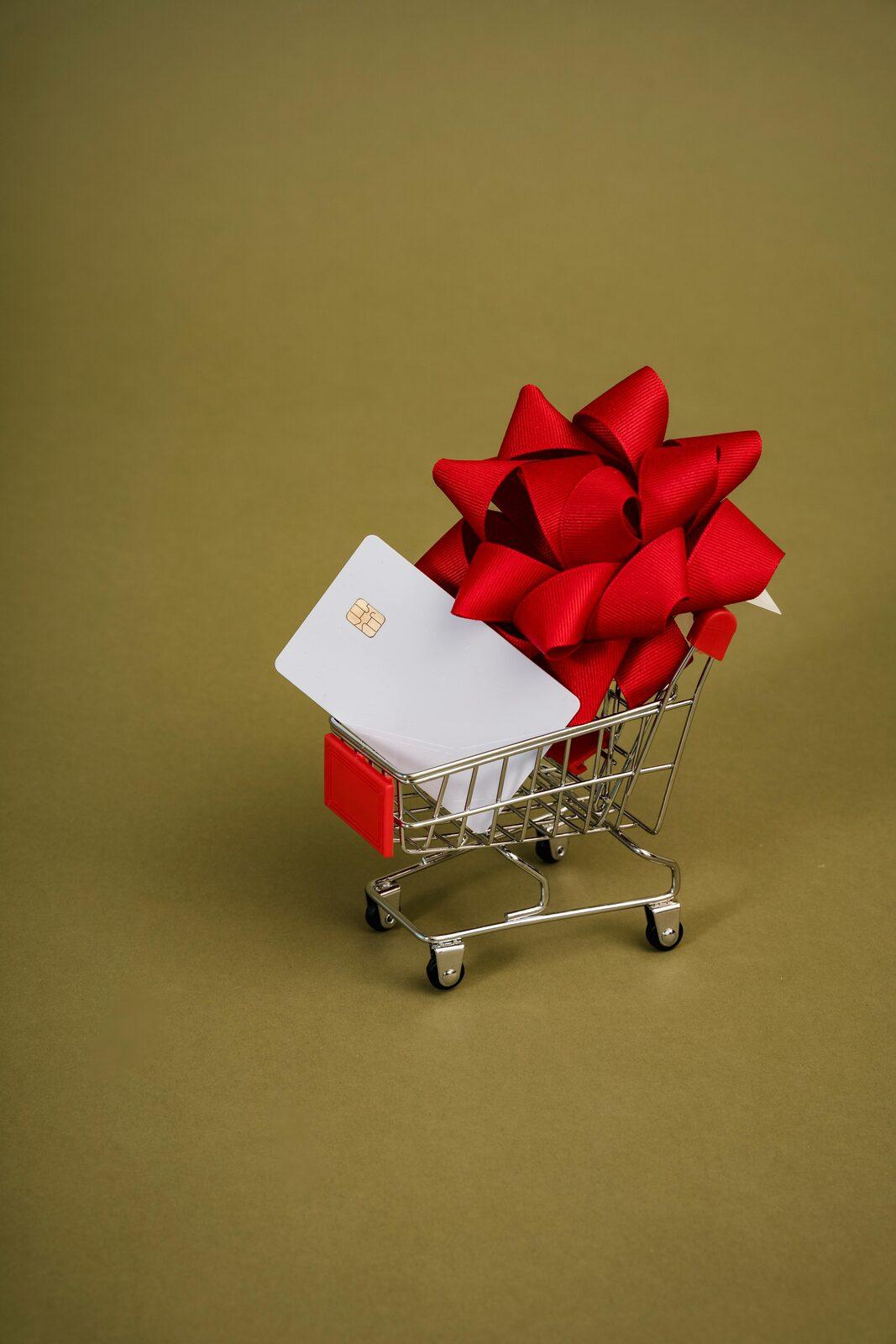 A small shopping cart holding a wrapped gift